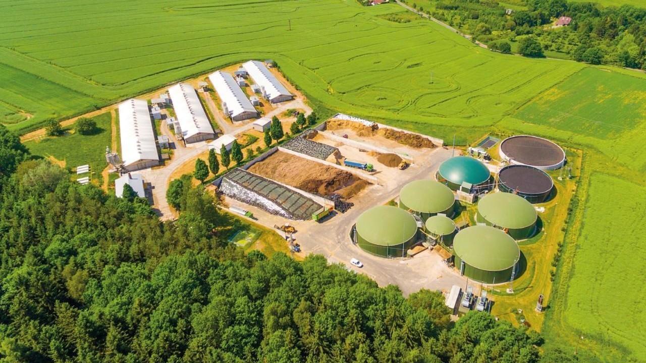 Aerial view over biogas plant and farm in green fields. Renewable energy from biomass. Modern agriculture in Czech Republic and European Union.